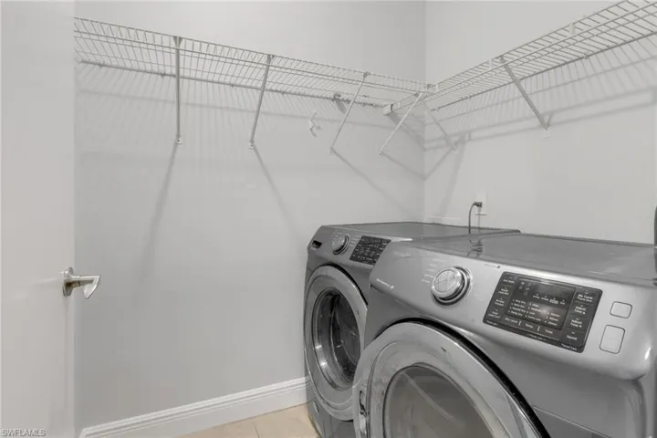 Washroom featuring separate washer and dryer and light tile patterned floors