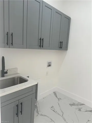 Laundry room with cabinets, sink, light tile floors, and hookup for a washing machine