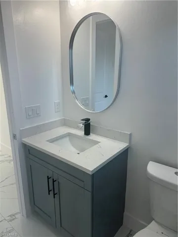 Bathroom with tile flooring, vanity, and toilet