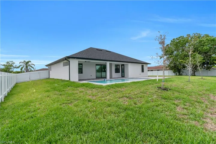 Rear view of house with a fenced backyard, a patio area, stucco siding, and a ceiling fan