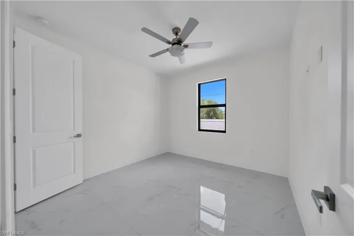 Spare room with light marble finish flooring and a ceiling fan