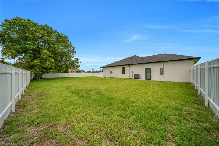 Back of property featuring a fenced backyard, stucco siding, and roof with shingles
