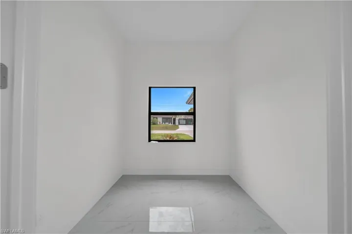 Unfurnished room with light marble finish flooring and baseboards
