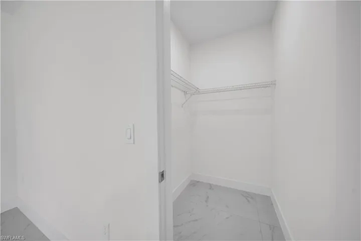 Spacious closet with light marble finish floors