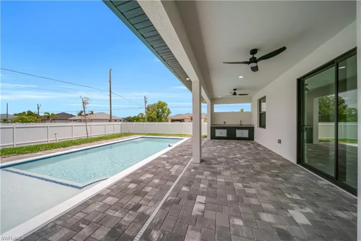 View of pool featuring a patio, ceiling fan, and a fenced backyard