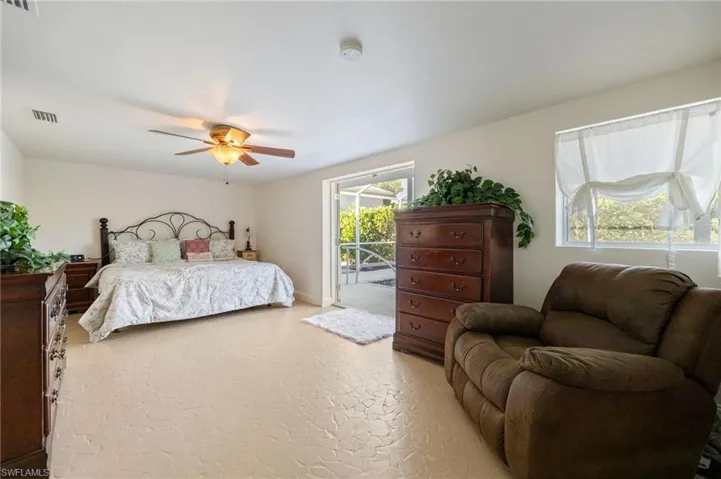 Carpeted bedroom with access to exterior and ceiling fan