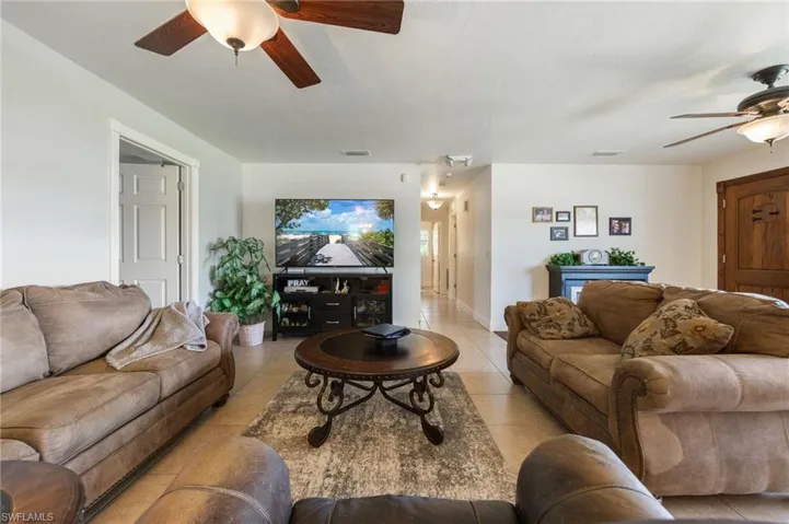 Living room with ceiling fan and tile patterned floors