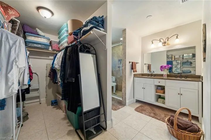 Walk in closet with light tile patterned floors