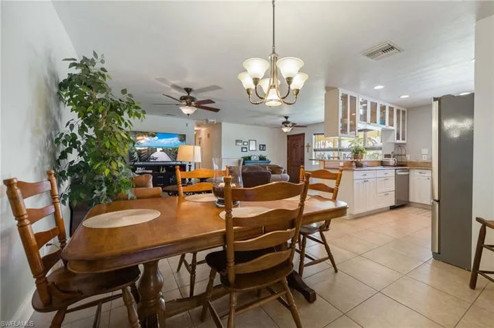 Dining room featuring a chandelier, light tile patterned floors, a ceiling fan, and recessed lighting