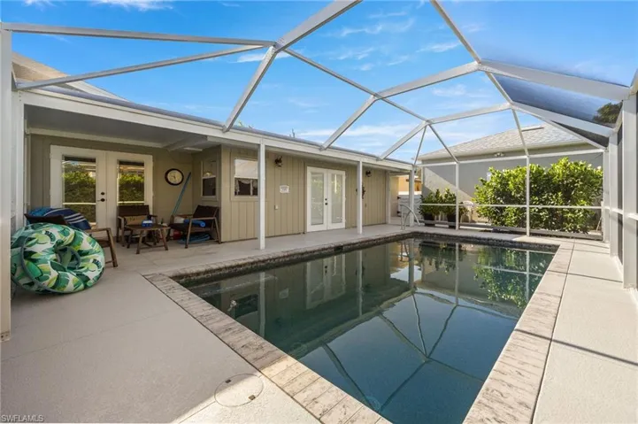 Outdoor pool featuring french doors, a lanai, a sunroom, and a patio area