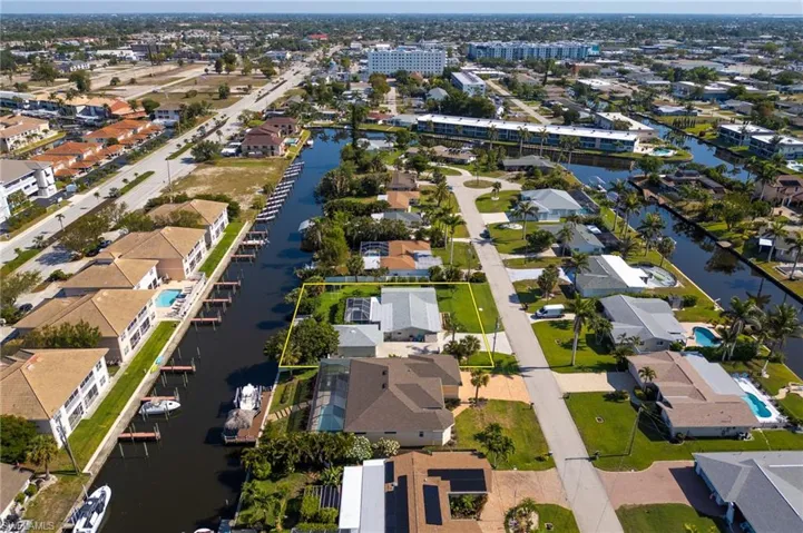 Aerial view of property and surrounding area featuring a large body of water and nearby suburban area