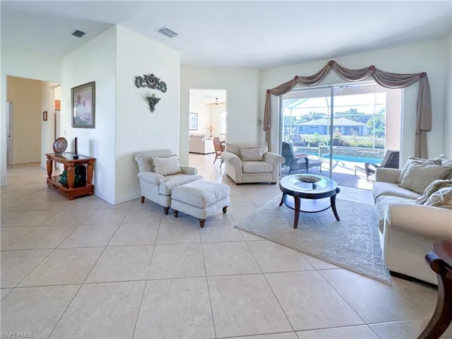 Living room with light tile patterned floors and a sunroom