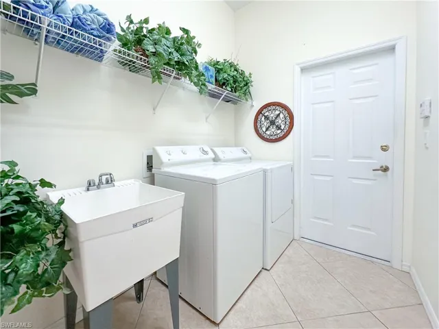 Washroom featuring washer and dryer and light tile patterned flooring