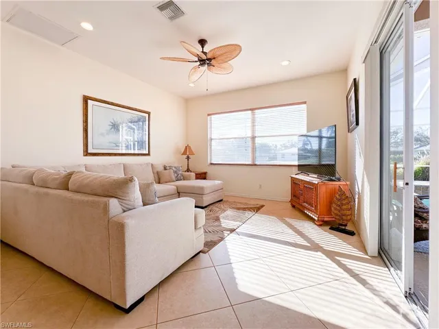 Living area with a ceiling fan, light tile patterned floors, and recessed lighting