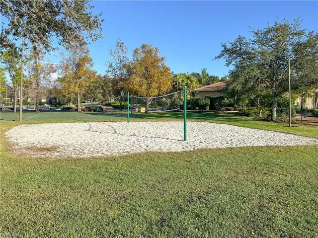 View of home's community featuring volleyball court and a lawn