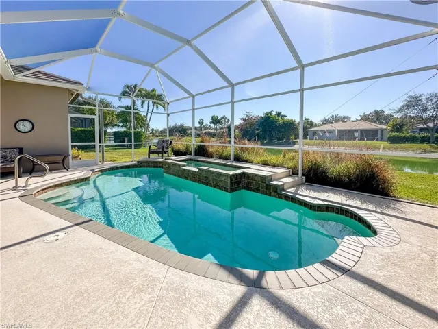 View of swimming pool with a patio, a sunroom, and glass enclosure