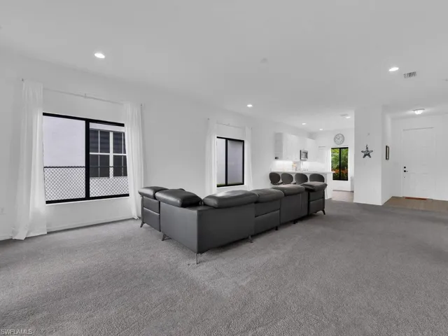 Living room featuring light colored carpet and recessed lighting