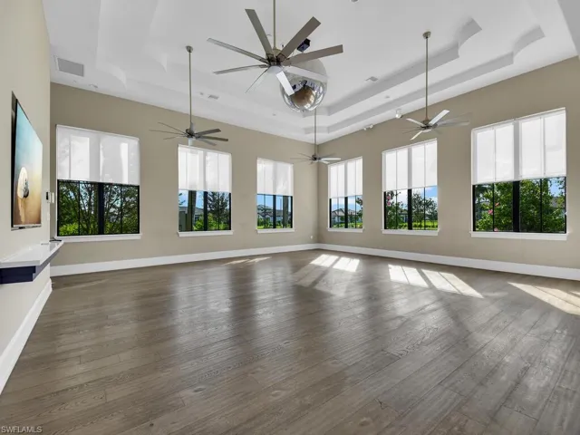 Unfurnished living room featuring dark wood finished floors and a tray ceiling
