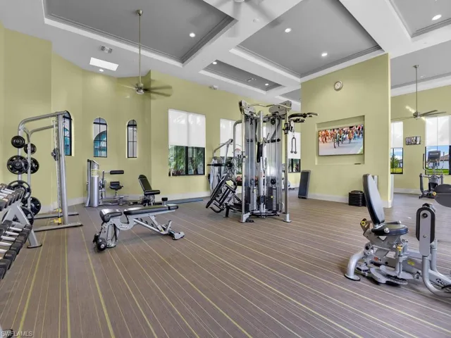 Gym featuring ceiling fan, high coffered ceiling, and crown molding