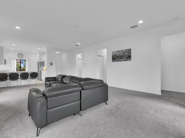 Living area featuring light carpet and recessed lighting