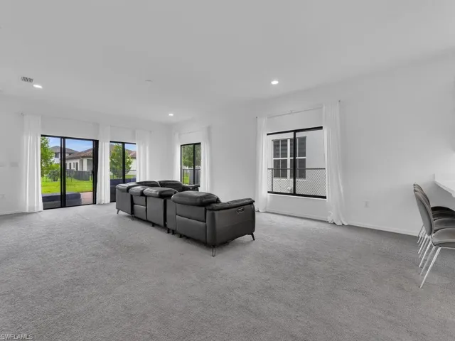 Living room featuring healthy amount of natural light, recessed lighting, and light colored carpet