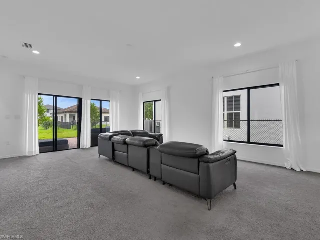 Living room with carpet flooring, healthy amount of natural light, and recessed lighting
