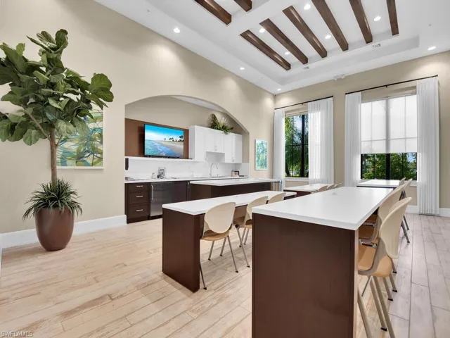 Kitchen with a breakfast bar, light wood-type flooring, recessed lighting, stainless steel refrigerator, and decorative backsplash