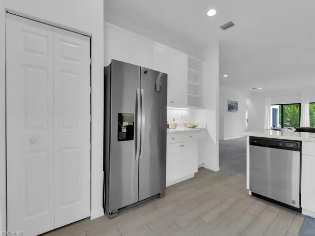 Kitchen featuring stainless steel appliances, open shelves, white cabinets, and recessed lighting