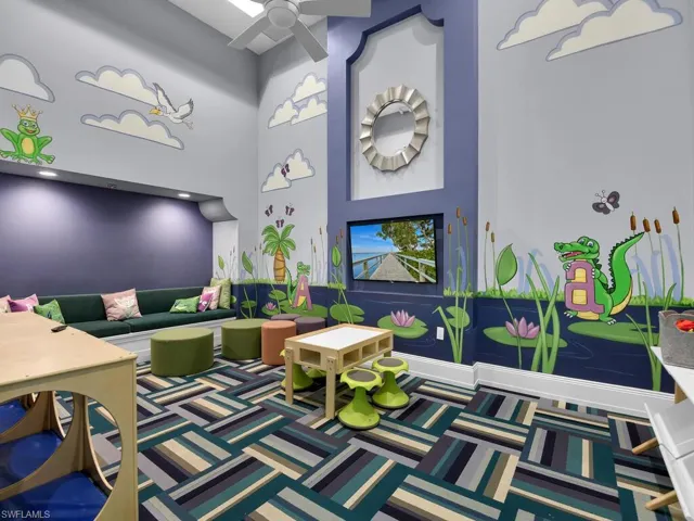 Rec room featuring a high ceiling and ceiling fan
