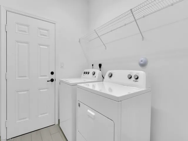 Laundry area with independent washer and dryer and light wood-style floors