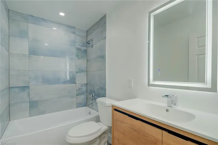 Bathroom featuring vanity, tub / shower combination, and recessed lighting