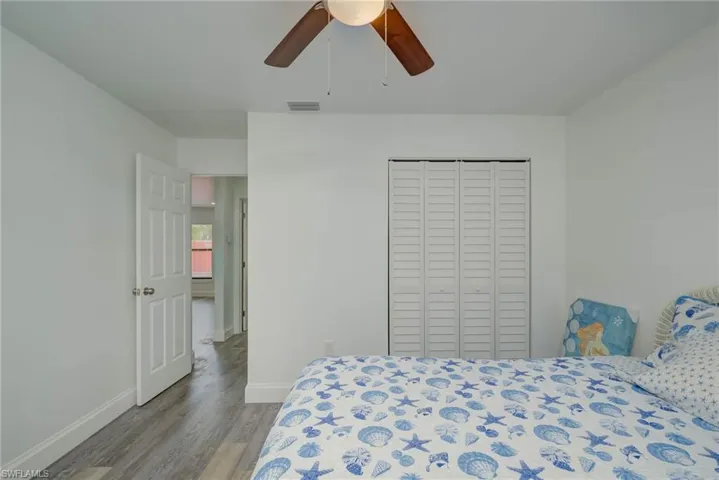 Bedroom with wood finished floors, a closet, and ceiling fan