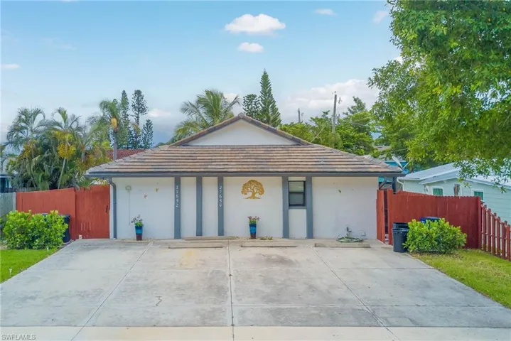 View of front facade featuring stucco siding and a tile roof