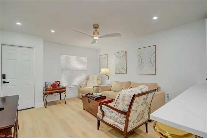 Living area with light wood-type flooring, ceiling fan, and recessed lighting