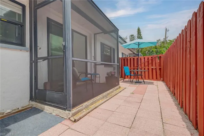 Fenced backyard with a sunroom and a patio