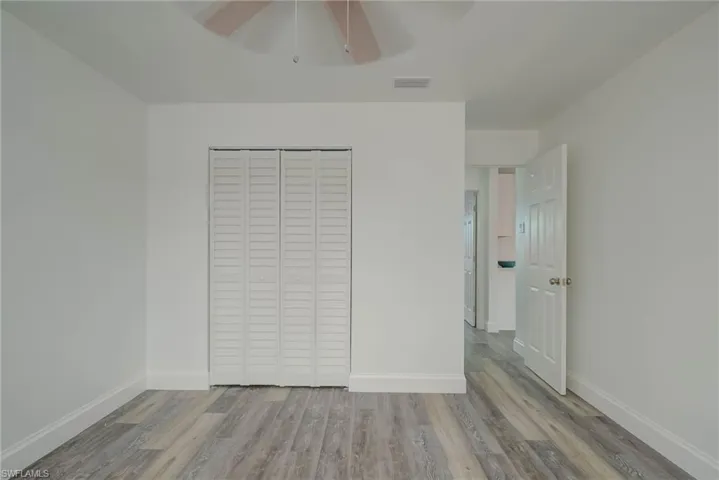 Unfurnished bedroom featuring wood finished floors, a closet, and ceiling fan