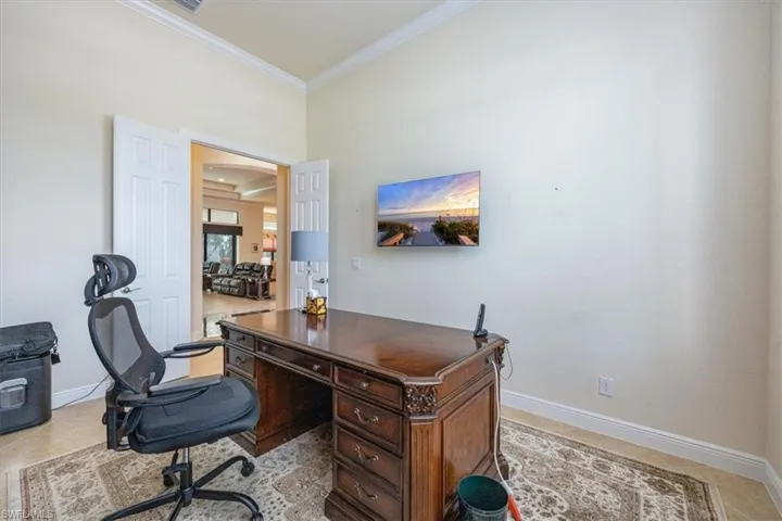 Office area with crown molding and light tile patterned floors