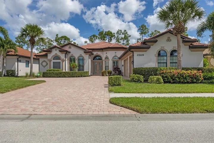 Mediterranean / spanish-style home with decorative driveway, stucco siding, french doors, and a tiled roof