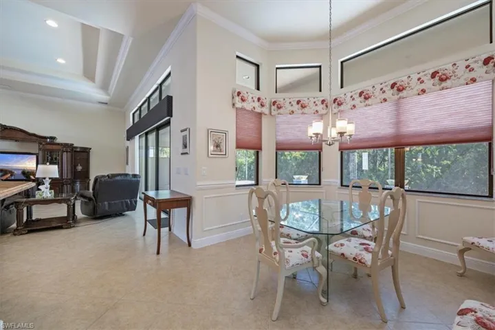 Dining space with crown molding and a chandelier