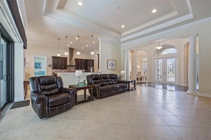 Building lobby with ornamental molding, recessed lighting, and a high ceiling