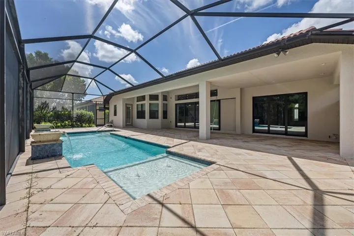 Swimming pool with a patio and glass enclosure