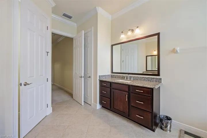 Bathroom with vanity, tile patterned floors, and crown molding