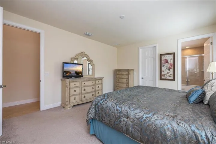Bedroom featuring carpet flooring and ensuite bathroom