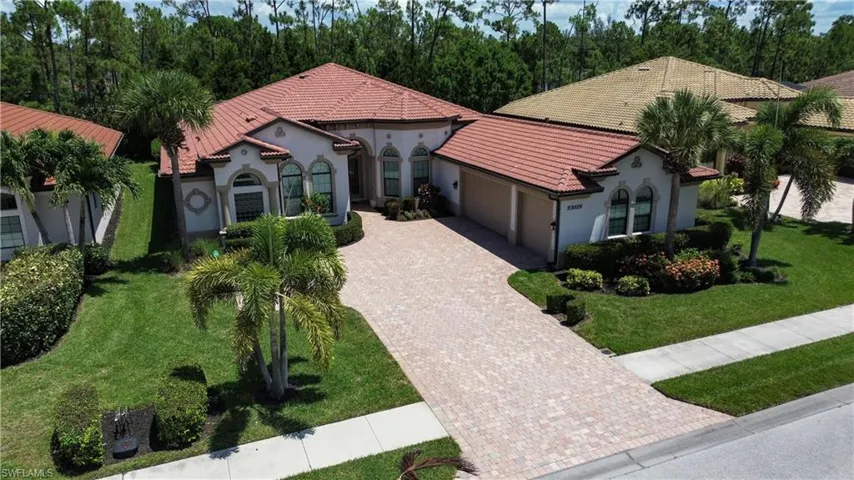 Mediterranean / spanish home featuring an attached garage, decorative driveway, stucco siding, a front lawn, and a tile roof