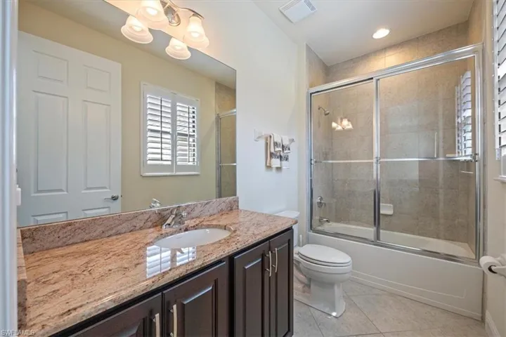 Full bathroom with vanity, combined bath / shower with glass door, and tile patterned floors