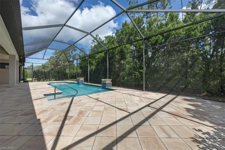 Swimming pool featuring a patio and glass enclosure