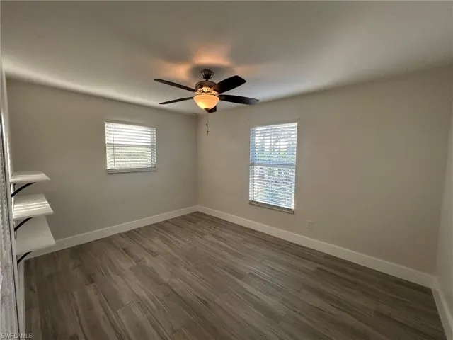Unfurnished room featuring gray tile- flooring, healthy amount of natural light, and ceiling fan