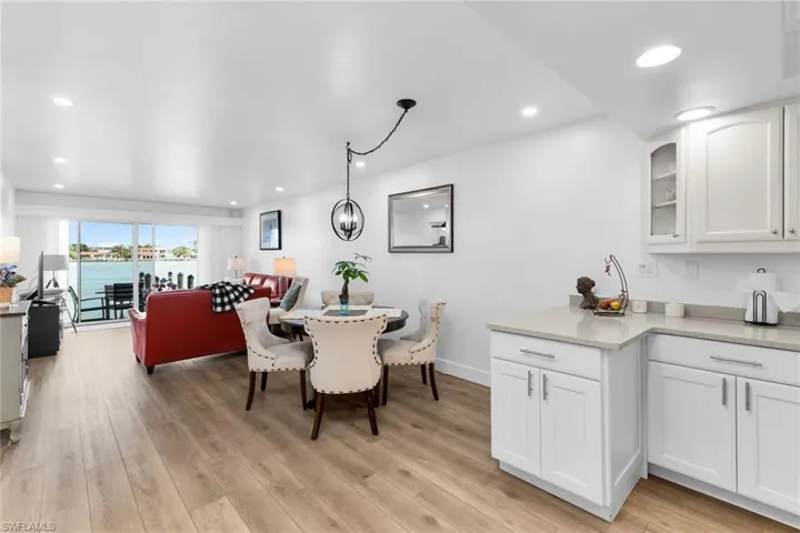 Dining room with light wood finished floors, recessed lighting, and a water view
