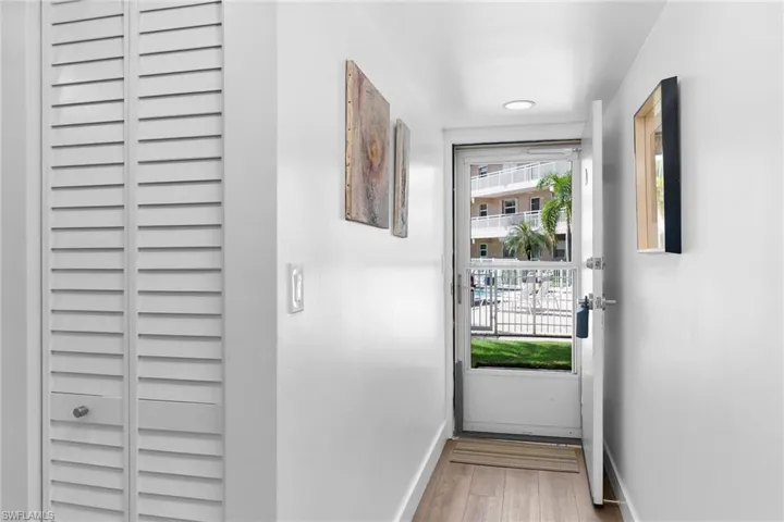 Doorway featuring baseboards and wood finished floors leading out to pool area