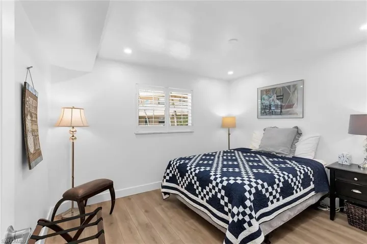 Guest bedroom featuring light wood-style floors and recessed lighting